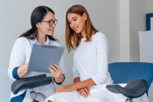 Gynecologist talking with young female patient during medical consultation