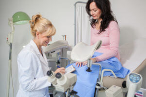 Gynaecologist performing pap smear test over a patient