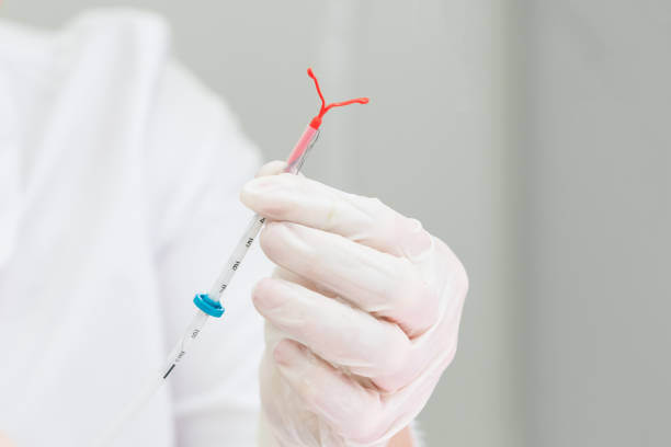 Holding an IUD birth control copper coil device in hand, used for contraception - front view