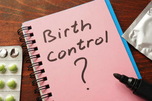 Notebook with the words Birth control on the table.